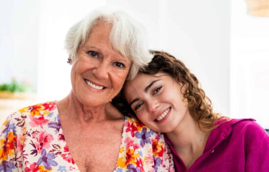 Beautiful grandmother and adult granddaughter together at home